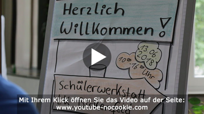 Das Bild zeigt einen Flipchart, auf dem "Herzlich Willkommen!" und "Schülerwerkstatt LK Birkenfeld" steht.